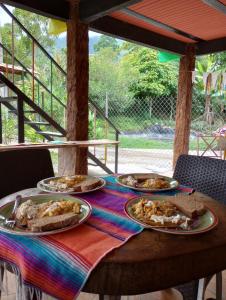 une table avec trois assiettes de pizza dessus dans l'établissement Los Laureles, à Calarcá