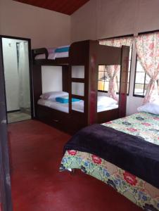 a bedroom with two bunk beds and a mirror at Los Laureles in Calarcá