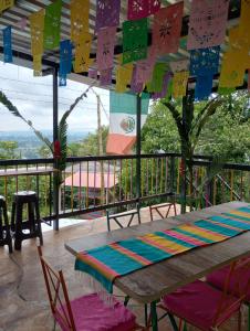 une table et des chaises sur un balcon avec drapeaux dans l'établissement Los Laureles, à Calarcá