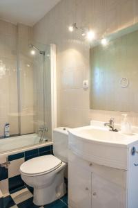 a bathroom with a toilet and a sink and a mirror at Yedrada Alojamientos in La Adrada