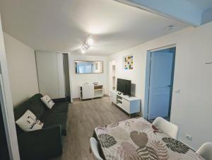 mały salon z łóżkiem i telewizorem w obiekcie Appartements avec terrasse proche métro - Paris à 25min w mieście Créteil