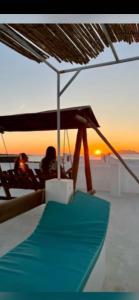 a table with a umbrella on the beach with the sunset at Villa Baya in El Haouaria