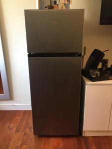 a black refrigerator in a kitchen next to a counter at Merazur in Fréjus