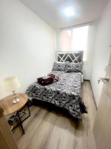 1 dormitorio con 1 cama y 1 mesa con lámpara en *Hermoso y cómodo apartamento cerca al aeropuerto, en Bogotá