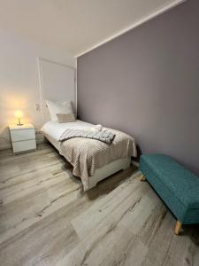 a bedroom with a bed and a green ottoman at Home Inn Apartments - 201 in Minden