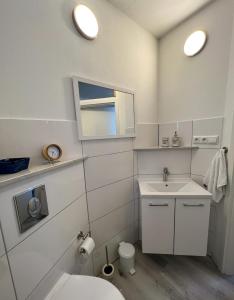 a white bathroom with a sink and a toilet at Home Inn Apartments - 201 in Minden