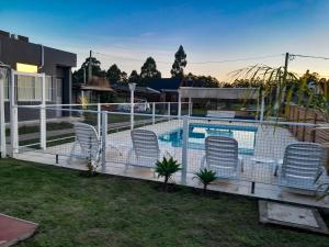 a fence around a swimming pool with chairs in a yard at Complejo EQUE PORA in Federación