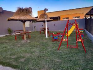 a yard with a playground with a slide and an umbrella at Complejo EQUE PORA in Federación