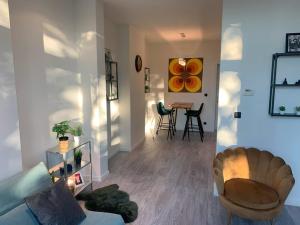 a living room with a couch and a table with chairs at Royal South - Apartment Antwerp with Parkview in Antwerp