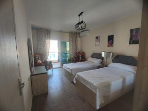 a hotel room with two beds and a couch at الداون تاون العالمين الجديدة خلف الابراج_ElDown Town New alameim in El Alamein