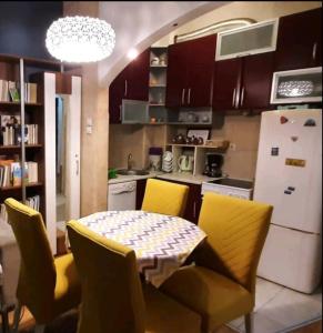 a kitchen with a table and chairs and a refrigerator at Dream S in Niš