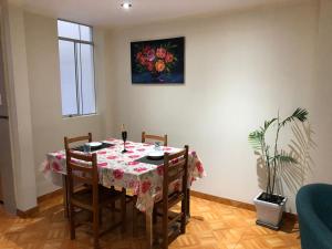 a dining room table with chairs and a painting on the wall at Hermoso departamento en lugar centrico in Trujillo