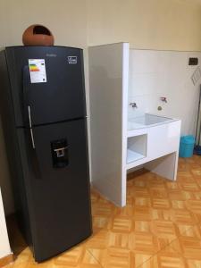 a black refrigerator in a kitchen with a cabinet at Hermoso departamento en lugar centrico in Trujillo