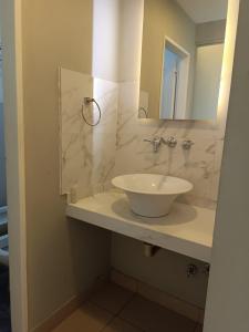 y baño con lavabo blanco y espejo. en LS Hotel en Salta