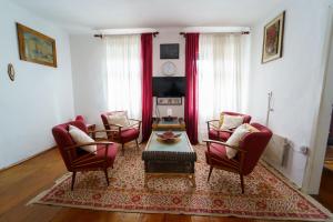 sala de estar con sillas rojas y mesa de centro en Wind & Water, en Delnice