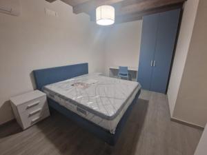 1 dormitorio pequeño con 1 cama y armario azul en Residence Mirella, en Acquafredda