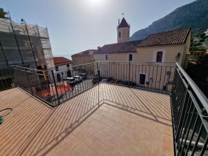 a wooden deck with a church and a building at Residence Mirella in Acquafredda