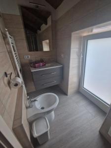 a small bathroom with a toilet and a sink at Residence Mirella in Acquafredda