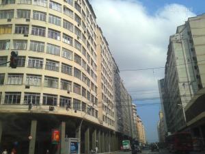 un edificio alto en una calle de la ciudad con un semáforo en STUDIO NITERÓI-BARCAS en Niterói