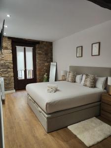 a bedroom with a large bed with a teddy bear on it at Brand new Port Relax with AC by Santiago in San Sebastián