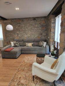 a living room with a couch and a stone wall at Brand new Port Relax with AC by Santiago in San Sebastián