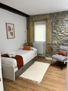 a bedroom with two beds and a stone wall at Brand new Port Relax with AC by Santiago in San Sebastián