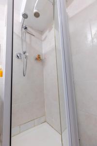 a shower with a glass door in a bathroom at Cosy 2 bedroom apartment near WEMBLEY, garden, late check in in London