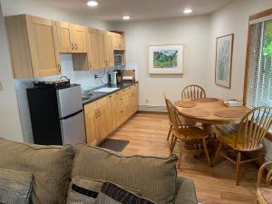 eine Küche und ein Esszimmer mit einem Tisch und einem Kühlschrank in der Unterkunft Cedar House in Jasper