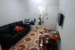 sala de estar con sofá negro y mesa en STUDIO NITERÓI-BARCAS en Niterói