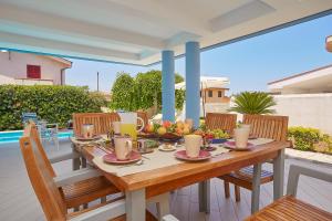 a wooden table with fruit on top of a balcony at Villa Costantino in Trappeto