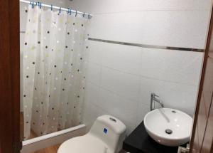 een badkamer met een wastafel, een toilet en een douche bij Maria Elena Rooms & Aparments . in Trujillo