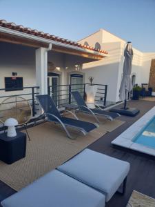 eine Terrasse mit Stühlen und einem Pool in der Unterkunft Casa das Almoleias in Castro Verde