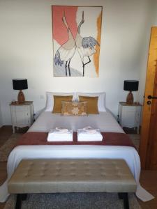 a bedroom with a large white bed with two tables at Casa das Almoleias in Castro Verde +47 photos