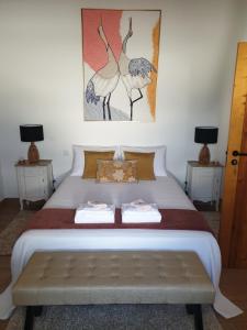 a bedroom with a large white bed with two tables at Casa das Almoleias in Castro Verde