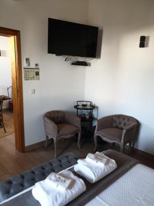 a room with a bed and two chairs and a flat screen tv at Casa das Almoleias in Castro Verde