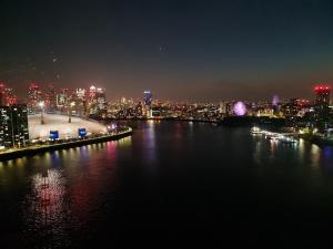 a view of a city at night with a body of water at Excel Manor in London