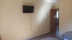 een kamer met een flatscreen-tv aan de muur bij Pousada Wunderland in Palmeira