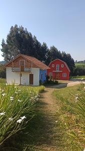 a couple of red and blue buildings in a field at Pousada Wunderland in Palmeira