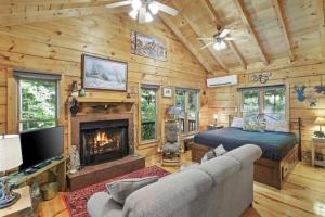 een woonkamer met een bed en een open haard bij Open Studio Lodge at Little Rock Creek in Cherry Log