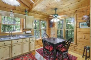 a kitchen with a table and chairs in a cabin at Open Studio Lodge at Little Rock Creek in Cherry Log