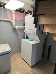 eine Waschküche mit einem kleinen Kühlschrank und einer Waschmaschine in der Unterkunft Lakin' It Easy in Middlebury