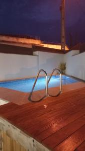 uma piscina com um corrimão de metal num deque de madeira em Casa do Alfaiate - Douro em Peso da Régua