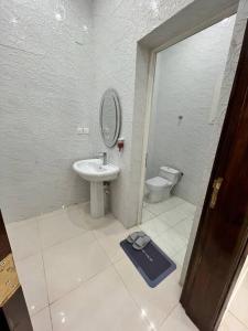 ein Badezimmer mit einem Waschbecken, einem Spiegel und einem WC in der Unterkunft شقة مميزه في القنفذة in Al Qunfudhah