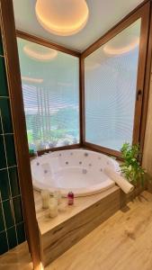 eine Badewanne in einem Zimmer mit einem großen Fenster in der Unterkunft Mid-Century Veek - puro diseño in Belén de Escobar