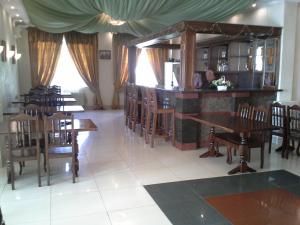 a restaurant with wooden tables and chairs and a counter at Dnister Hotel Complex in Zhvanets
