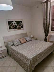 ein Schlafzimmer mit einem Bett mit einer grauen Bettdecke in der Unterkunft Casa Bezzecca La Spezia in La Spezia