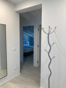 La Casa sul Lago Apartments - Blue Wave Apartment في ليموني سول غاردا: غرفة بسرير وتمثال شجرة