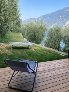 einen Stuhl auf einer Terrasse mit einem Picknicktisch in der Unterkunft La Casa sul Lago Apartments - Blue Wave Apartment in Limone sul Garda