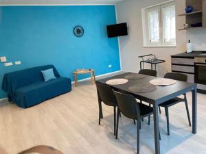 ein Wohnzimmer mit einem Tisch und einem Sofa in der Unterkunft La Casa sul Lago Apartments - Blue Wave Apartment in Limone sul Garda