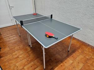 una mesa de ping pong con raqueta de tenis. en Casa Sebastian, en L'Escala